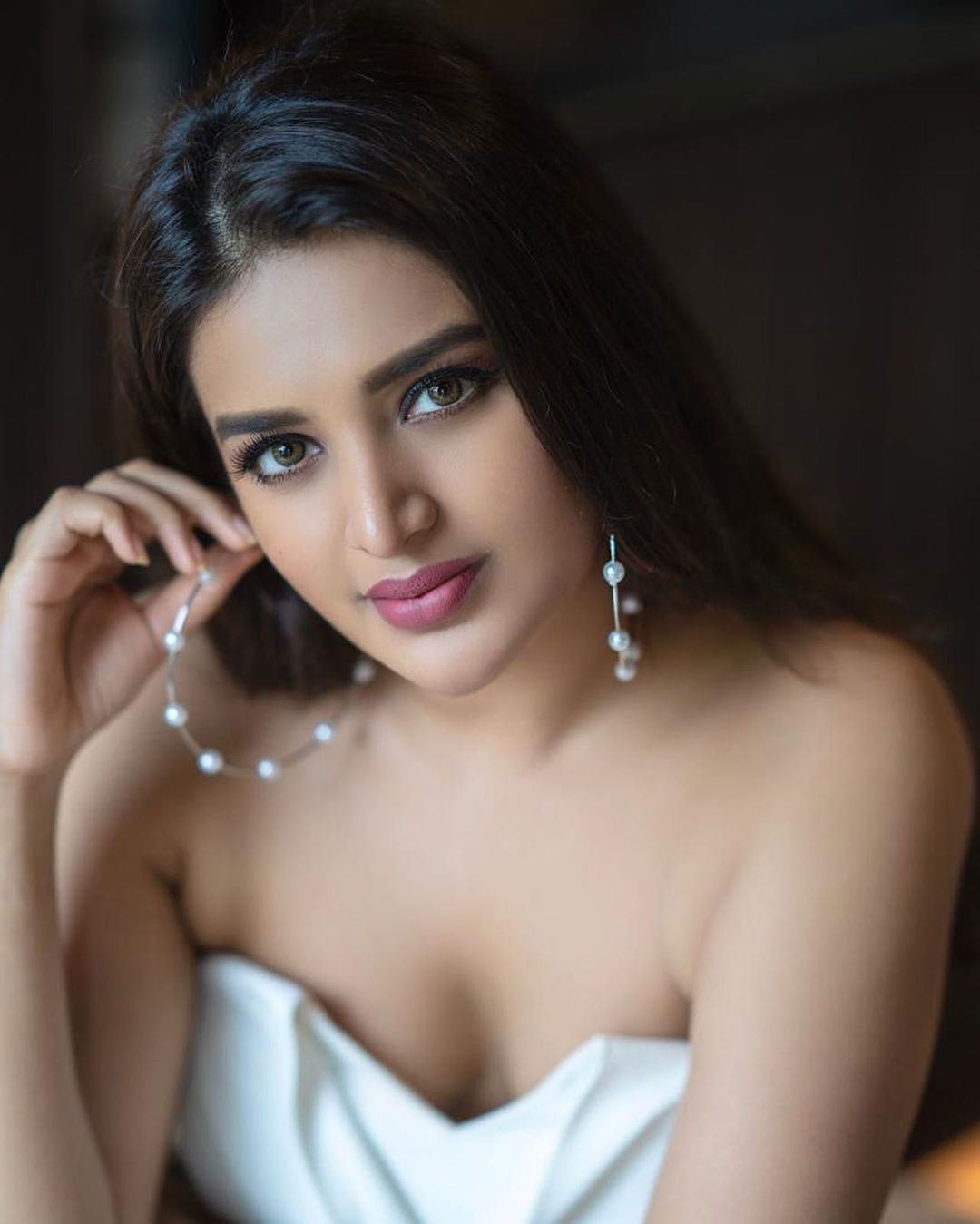 Nidhhi Agerwal stills in white dress on the bed